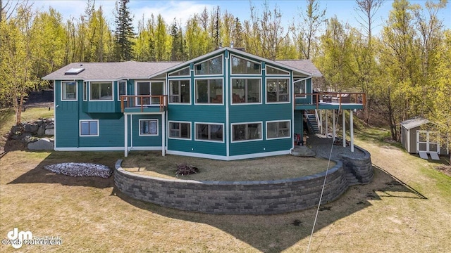 back of house with a sunroom, a yard, a shed, and a deck