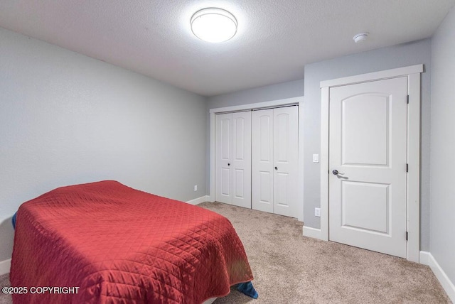 carpeted bedroom with a textured ceiling and a closet