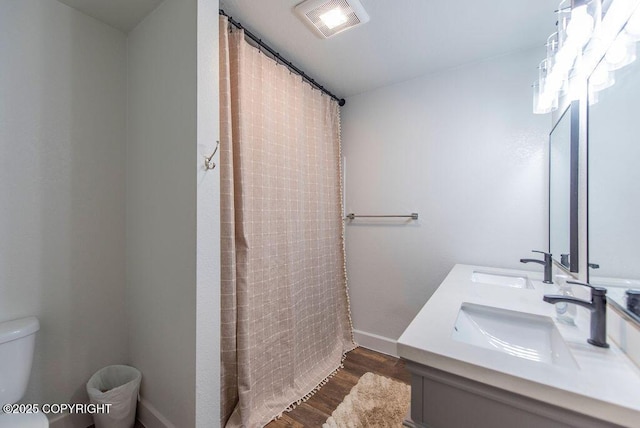 bathroom with curtained shower, hardwood / wood-style floors, vanity, and toilet