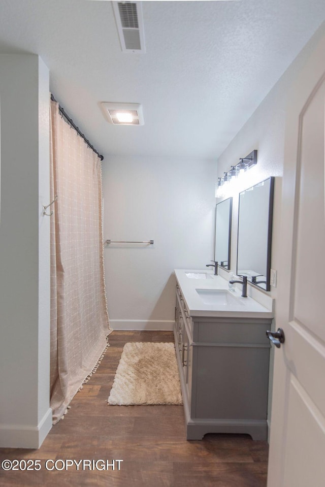 bathroom featuring a shower with shower curtain, hardwood / wood-style floors, vanity, and a textured ceiling