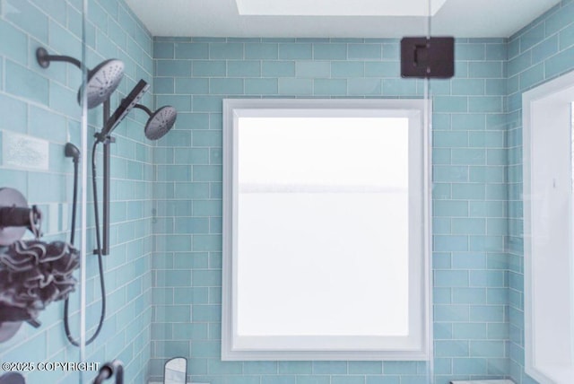 bathroom featuring a tile shower and a wealth of natural light