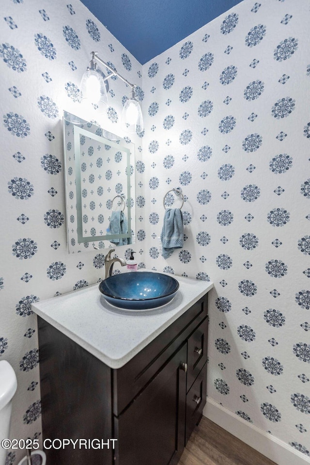 bathroom with hardwood / wood-style floors, vanity, and toilet