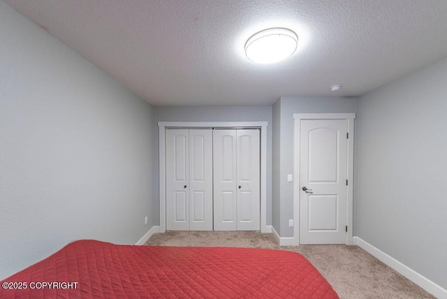 unfurnished bedroom with light carpet, a textured ceiling, and a closet