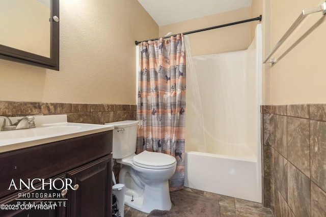 full bathroom with vanity, toilet, shower / bathtub combination with curtain, and tile walls