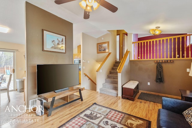 living room with ceiling fan, wood-type flooring, and lofted ceiling