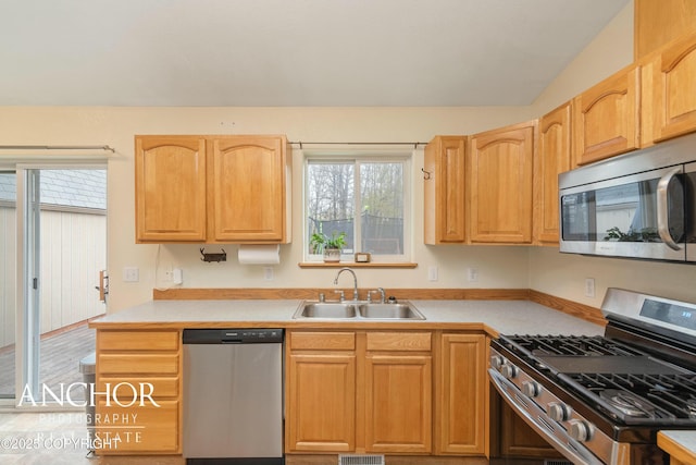 kitchen with light brown cabinetry, sink, and appliances with stainless steel finishes