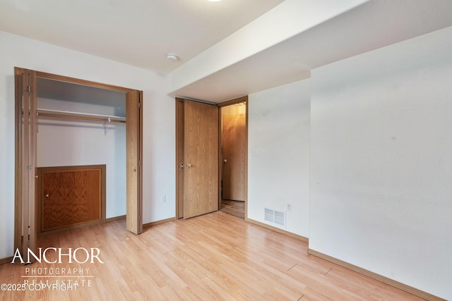 unfurnished bedroom featuring light wood-type flooring and a closet