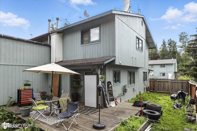8281 Stratton Cir, Anchorage, AK 99507 - back of property featuring a deck, a fenced backyard, and outdoor dining area