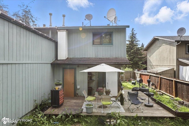 8281 Stratton Cir, Anchorage, AK 99507 - back of property with a fenced backyard, a wooden deck, and outdoor dining space