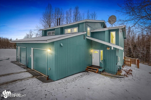 back house at dusk featuring a garage