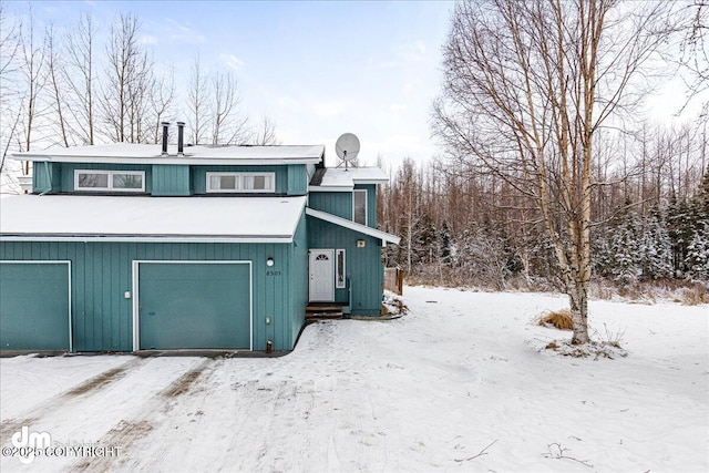 view of snowy exterior featuring a garage