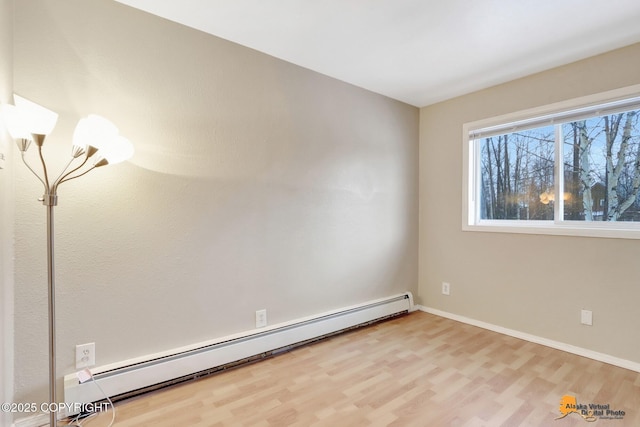 unfurnished room with hardwood / wood-style floors and a baseboard radiator