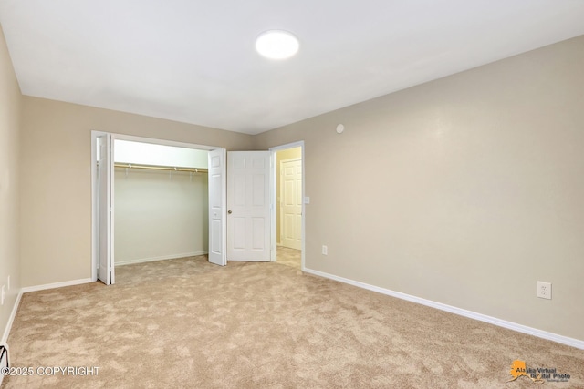 unfurnished bedroom with light colored carpet and a closet