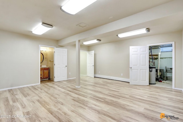 interior space with light hardwood / wood-style floors, ensuite bath, and water heater