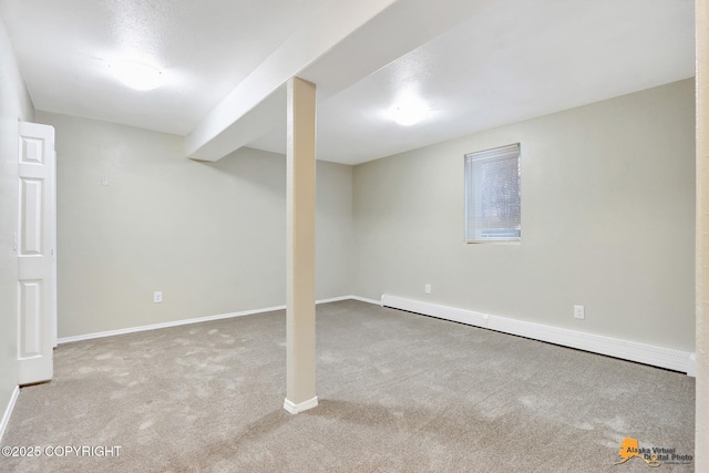 basement featuring light colored carpet and a baseboard radiator