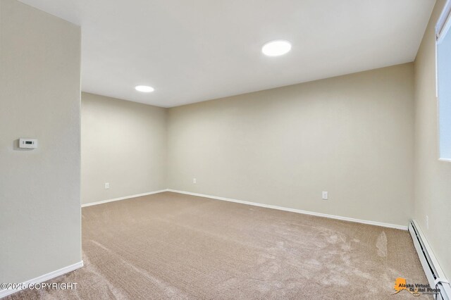 unfurnished room featuring light colored carpet and baseboard heating