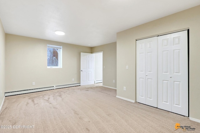 unfurnished bedroom with a closet, light carpet, and a baseboard heating unit