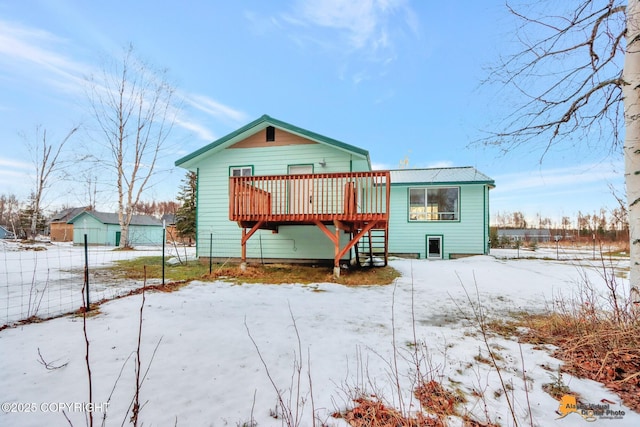 snow covered property with a wooden deck