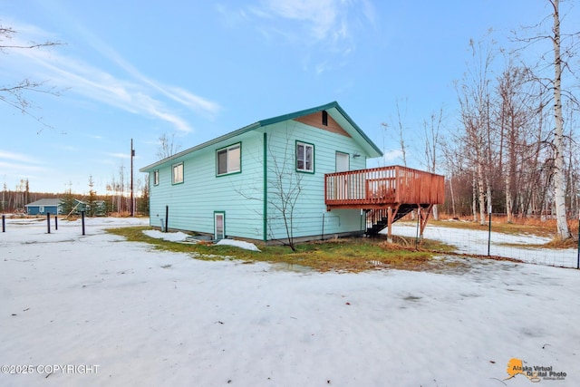 view of snowy exterior with a wooden deck