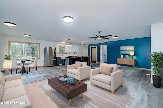 living room with light hardwood / wood-style floors and ceiling fan