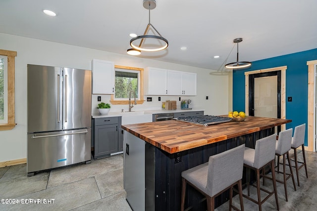 kitchen featuring gray cabinets, pendant lighting, white cabinets, and stainless steel appliances