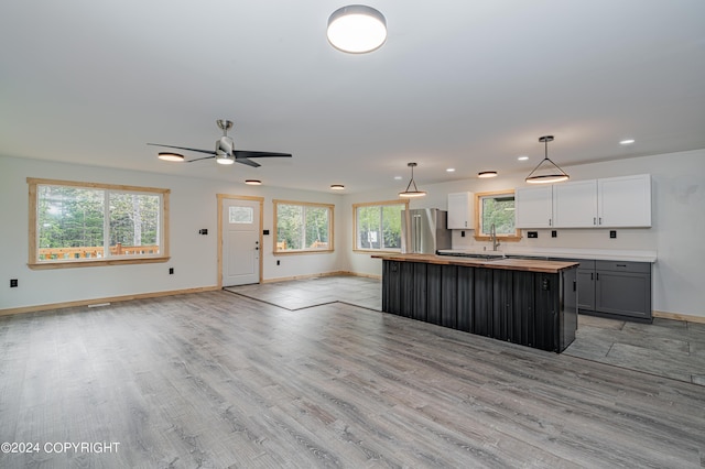 kitchen featuring high quality fridge, gray cabinetry, decorative light fixtures, white cabinetry, and a kitchen island