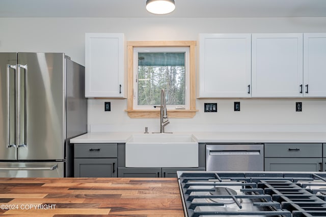 kitchen with white cabinets, gray cabinetry, sink, and appliances with stainless steel finishes