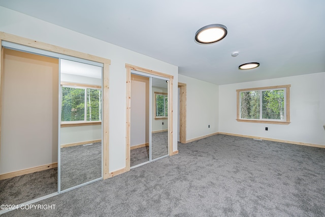 unfurnished bedroom featuring carpet flooring and multiple windows