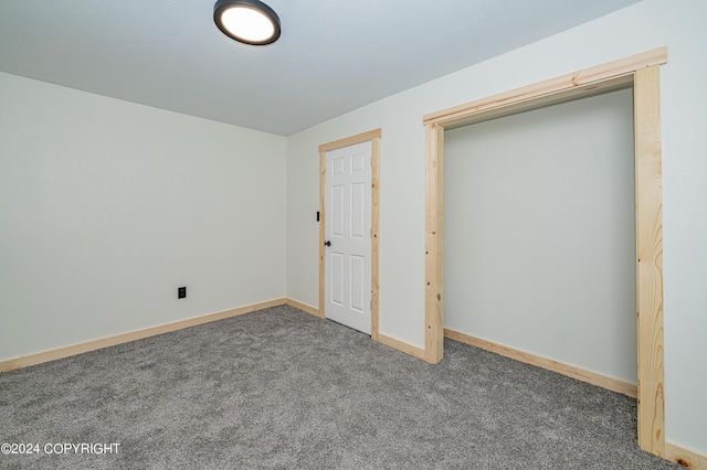 unfurnished bedroom with dark colored carpet