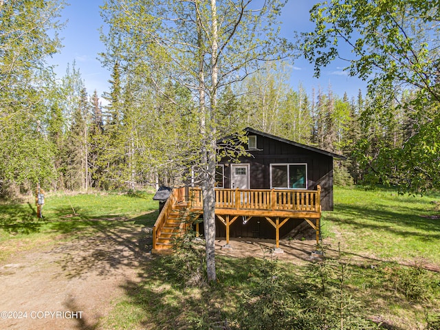 rear view of house with a yard and a deck