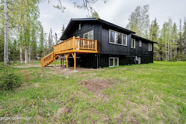 rear view of property with a yard and a wooden deck