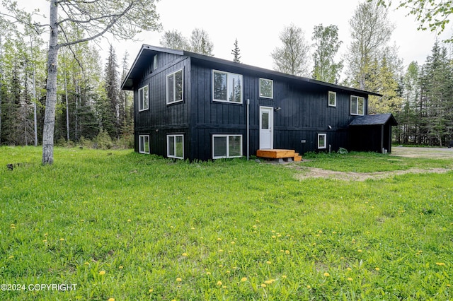 rear view of house featuring a yard