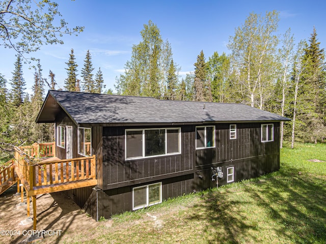 rear view of property with a deck and a lawn