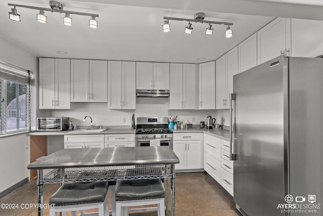 kitchen with a breakfast bar area, sink, white cabinets, and stainless steel appliances