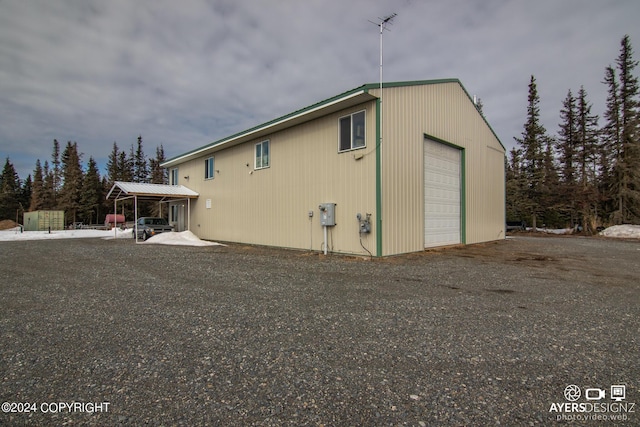 view of home's exterior with a garage and an outbuilding