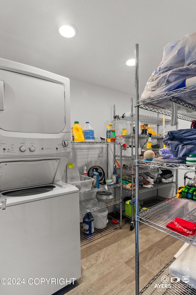 laundry area featuring light wood-type flooring and stacked washer and clothes dryer