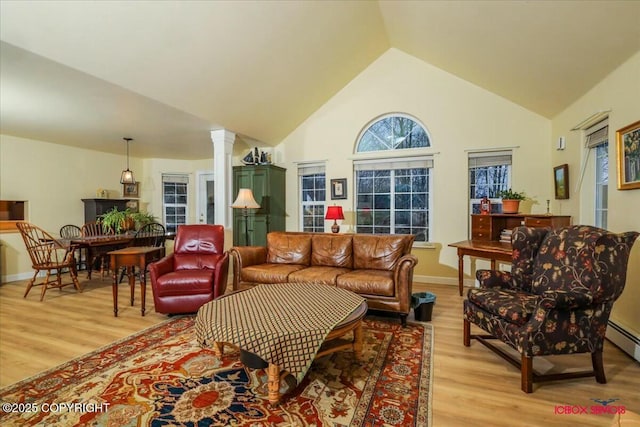 living room with light hardwood / wood-style floors, lofted ceiling, and ornate columns