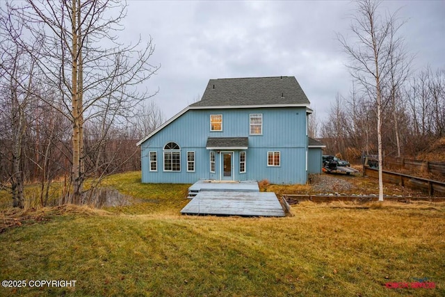 back of house featuring a lawn and a wooden deck