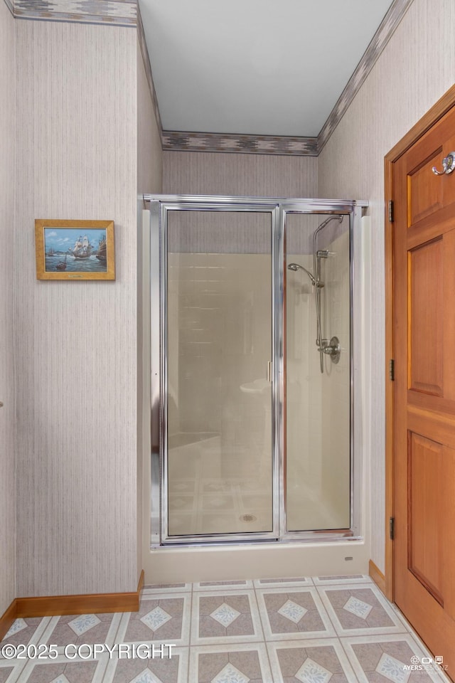 bathroom with crown molding and a shower with shower door