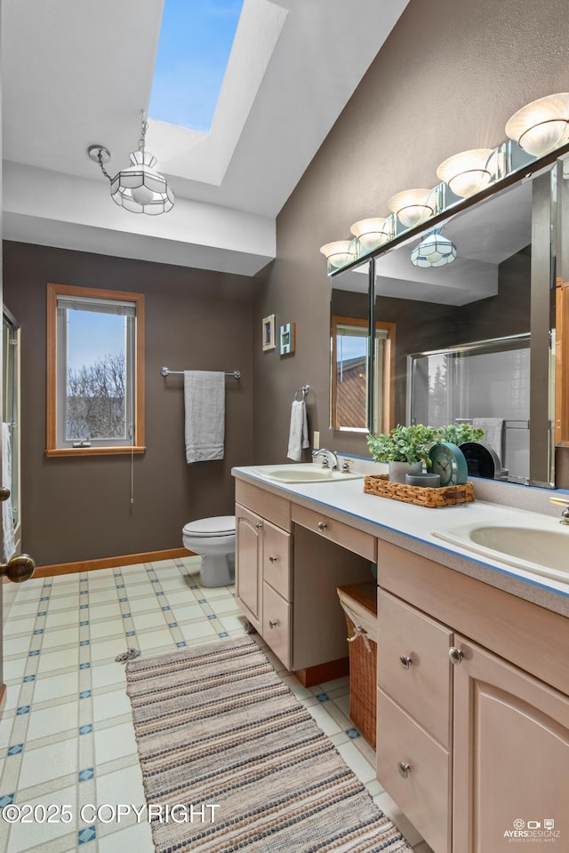 bathroom with lofted ceiling with skylight, vanity, a shower with shower door, and toilet