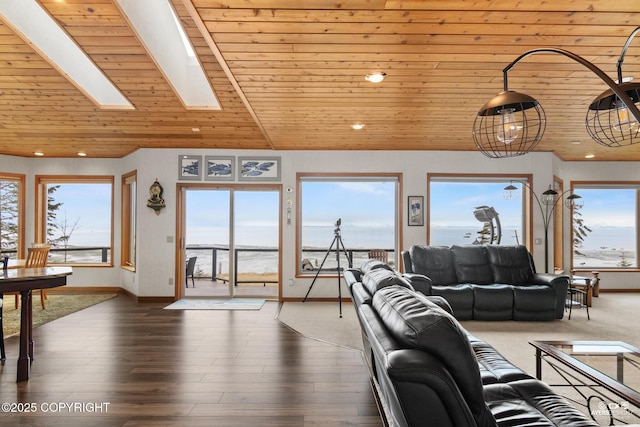 living room featuring a skylight, a healthy amount of sunlight, a water view, and wooden ceiling