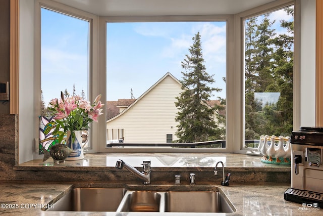 kitchen featuring dark stone countertops, sink, and plenty of natural light