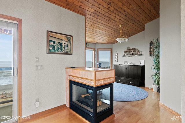 interior space featuring hardwood / wood-style flooring, a multi sided fireplace, and wood ceiling