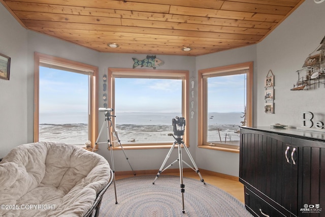 sitting room with a beach view, a water view, and wood ceiling