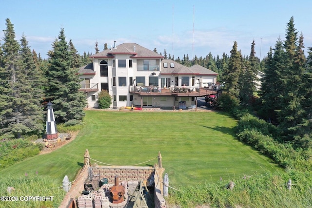 back of property with a lawn and a deck