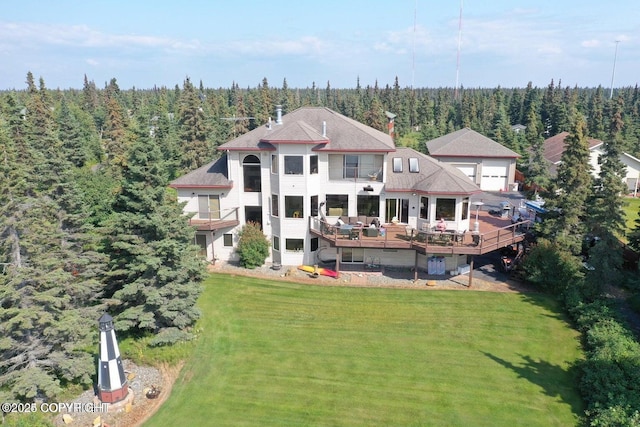 rear view of property featuring a lawn and a deck