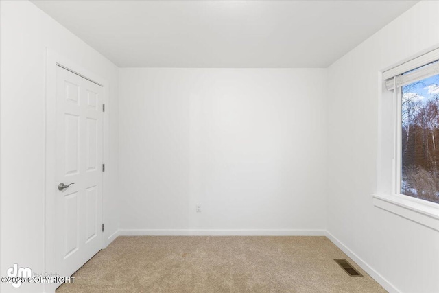 carpeted spare room featuring plenty of natural light