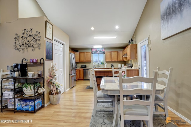 dining area featuring light wood-type flooring and sink