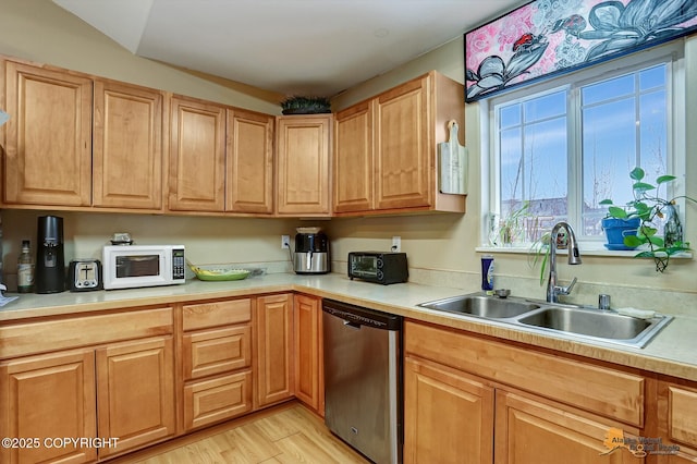 kitchen featuring stainless steel dishwasher, light wood-type flooring, and sink