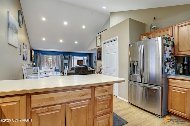 kitchen featuring stainless steel fridge, light hardwood / wood-style floors, and vaulted ceiling